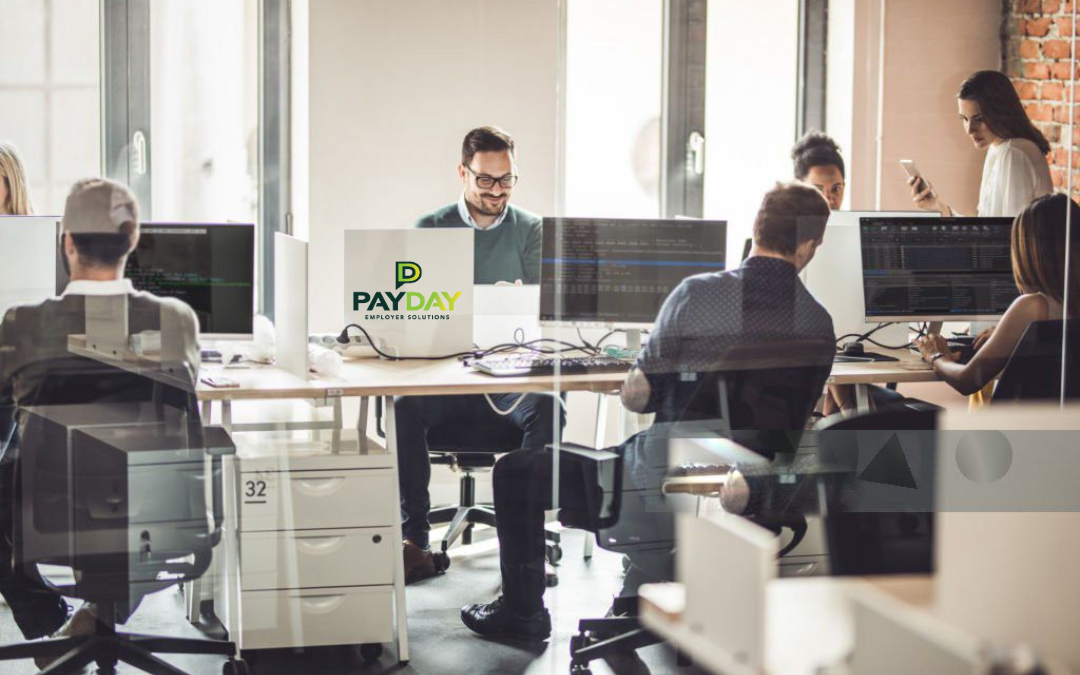 Modern office with employees using digital time-tracking tools on screens.