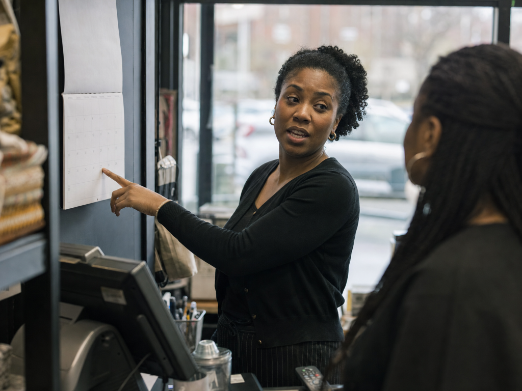Retail manager reviewing July 2026 minimum wage changes with staff