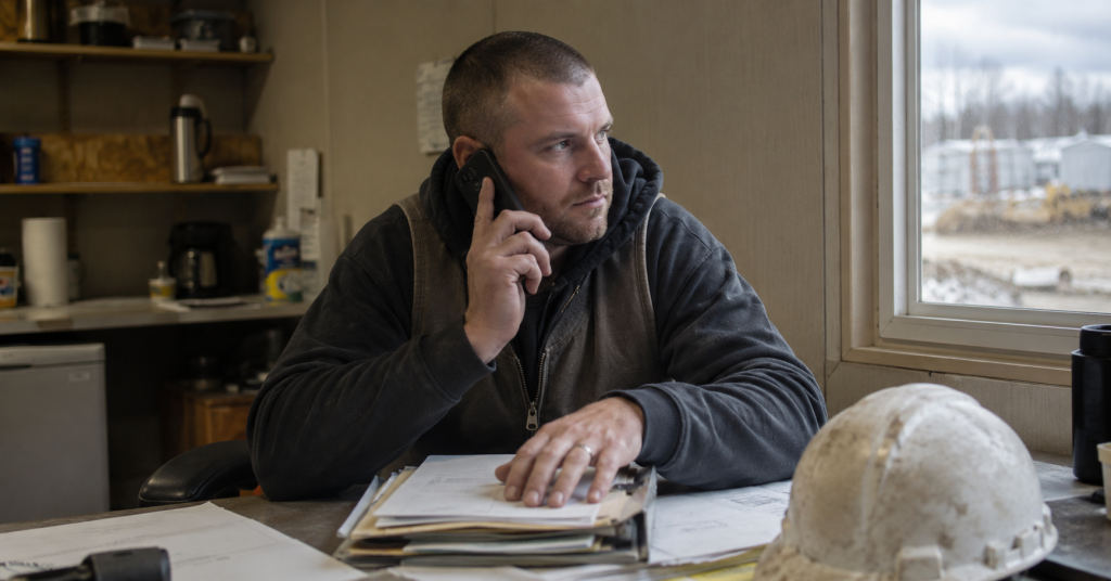 Employer coordinating enrollment checklist and payroll deduction updates by phone.